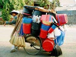 Typical seller of brooms and buckets travels the streets of Jakarta